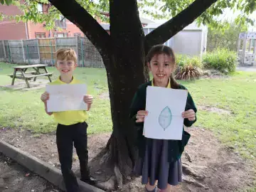 Students holding nature drawings