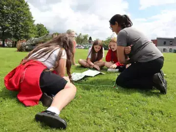 Students and teacher observe nature on their school field