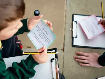 boy holding activity card with clipboard