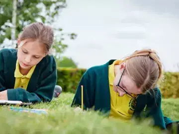 students writinngg on grass