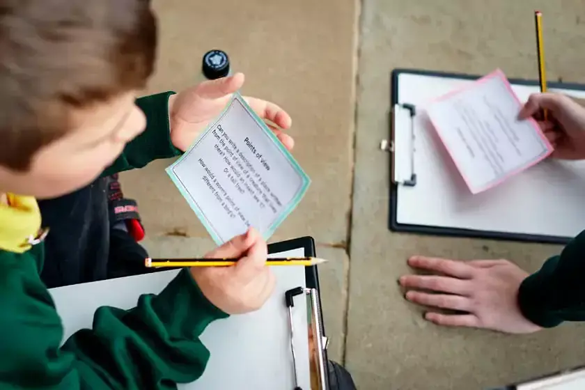 boy holding activity card with clipboard