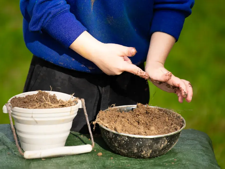 Child with a bucket of soil
