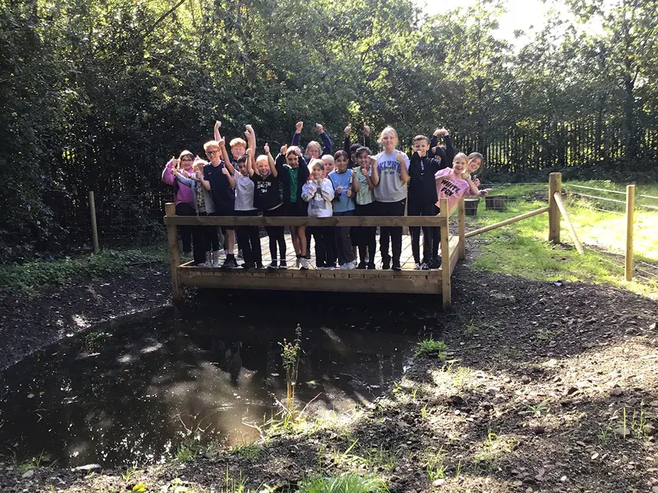 Pupils stand around a new pond area